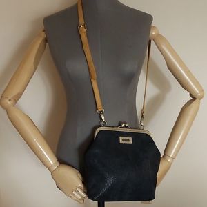 Cute black crossbody with kisslock closure. Not sure of the material.